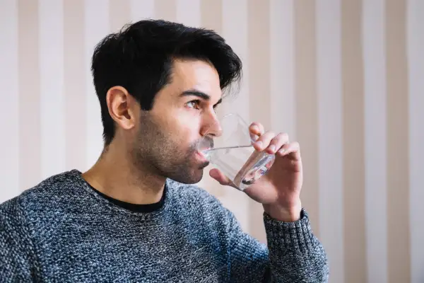 This image is of a person drinking cold water through a glass
