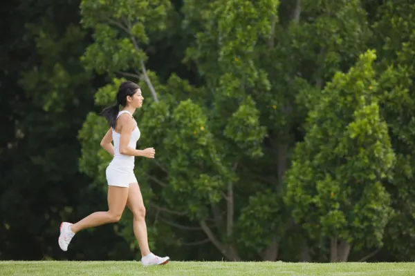 A woman jogging outdoors. Regular exercise is key to a plan to cure PCOD naturally.