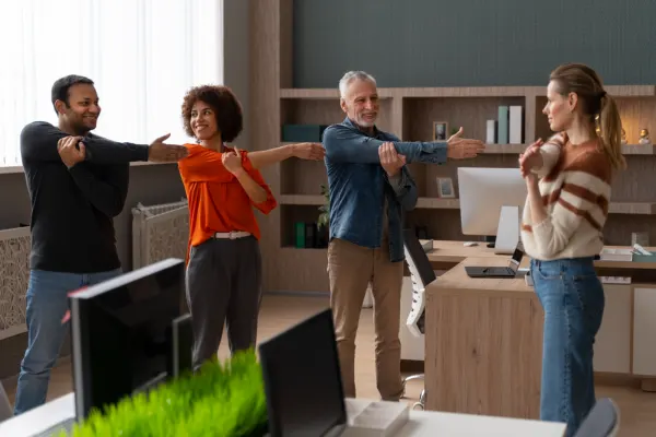 Employees stretching together in a modern office as part of effective Corporate Wellness Programs during work